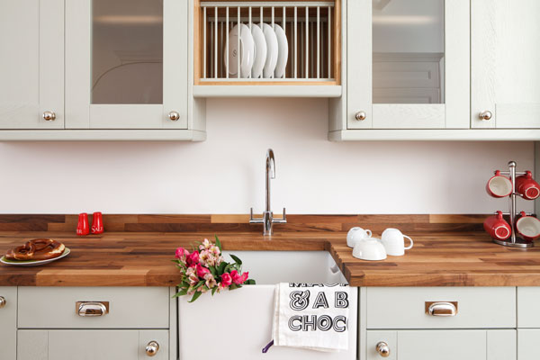 This kitchen features shaker cabinets in Farrow & Ball's mizzle with Walnut worktops and a Belfast sink